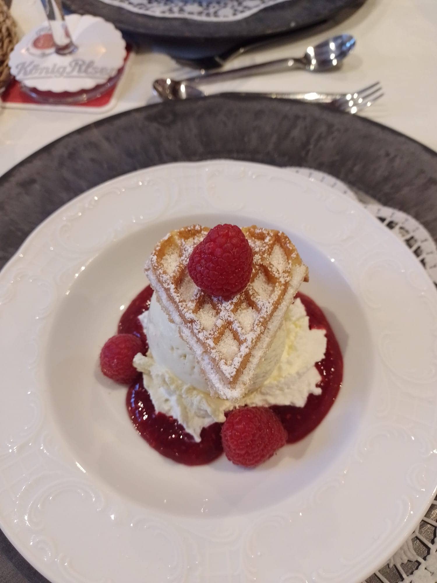 Dessert mit Waffel, Sahne und Himbeeren